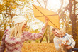 © chika_milan - Mother and father playing with son in park at autumn/ flying kite