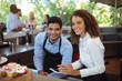 Male waiter and female waitress with digital tablet