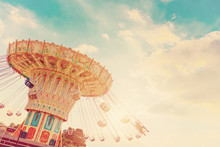Carousel Ride Spins Fast In The Air At Sunset - Vintage Filter Effects - A Swinging Carousel Fair Ride At Dusk