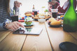 © lenets_tan - Top view of group of people having dinner together while sitting at wooden table. Food on the table. People eat fast food.