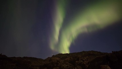Wall Mural - strong bright realistic aurora borealis over rocky volcanic terrain iceland 4k