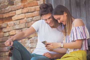 Young couple looking and using the app on smart phone
