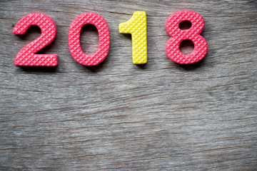 Canvas Print - Toy foam alphabet in wording 2018 on wood plate background (Concept for Happy new year decoration)