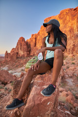 woman taking a break from hiking to drink water at valley of fire park