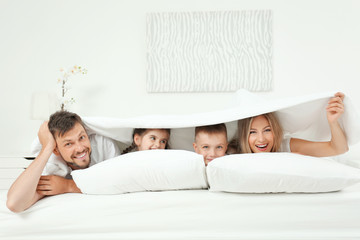 Canvas Print - Family lying on bed in hotel room