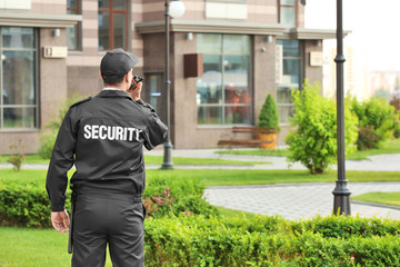 Male security guard with portable radio, outdoors