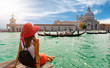 Attraktive Touristin am Canal Grande in Venedig schaut auf die Basilica Santa Maria della Salute