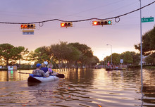 HOUSTON, USA - SEPTEMBER 2, 2017: Working Traffic Lights Over Flooded Houston Streets And Boats With People At Sunset