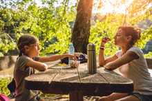 Mother And Daughter Eating At A Picnic Table