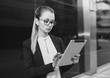 © xo4uphoto - Business woman with glasses using tablet, black and white