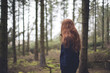 © CatMacBride/Stocksy - Red head in forest...
