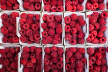 Cartons Of Fresh Raspberries At A Farmers' Market Stall.