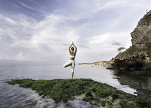 Woman Practicing Yoga At Sea Shore