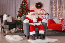 Authentic Santa Claus Sleeping In Armchair At Room Decorated For Christmas