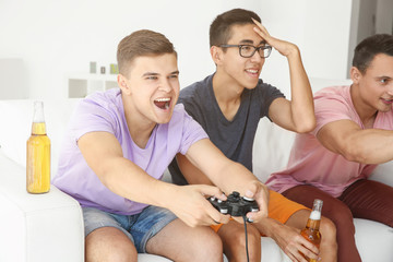 Wall Mural - Young men playing video games on TV at home