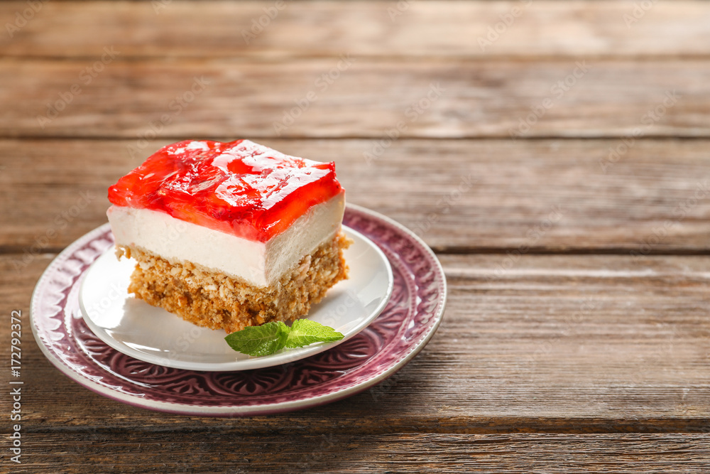 Plate with delicious strawberry pretzel salad on table
