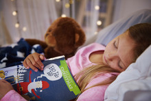 Small Girl Taking A Nap  With Book And Teddy Bear