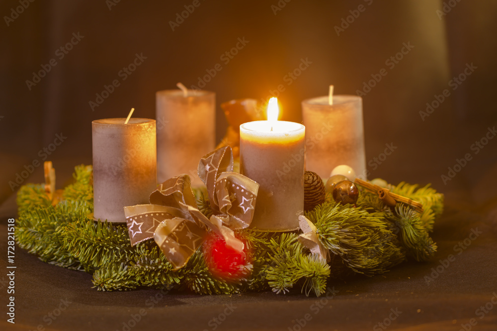 Erster Advent , Adventskranz mit einer brennenden Kerze Stock Photo