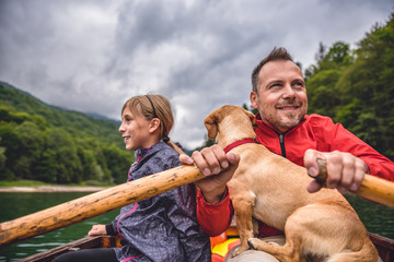 Wall Mural - Father and daughter with a dog rowing a boat