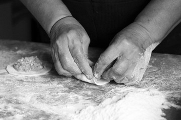 Female hands making dough for pizza