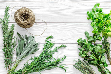 Poster - fresh herbs and greenery for spices and cooking on white wooden desk background top view mock up