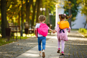 Two happy cheerful girls running to school