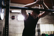 © Rob and Julia Campbell/Stocksy - Young caucasian man recovering from lifting weights in gritty workout gym