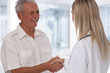 © dream@do - Smiling female doctor giving handshake to senior male patient. Healthcare concept