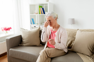 Wall Mural - senior woman with glasses having headache at home