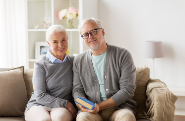 Poster - happy senior couple sitting on sofa at home