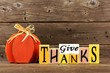 Shabby chic Give Thanks wood sign and pumpkin against a rustic wooden background