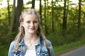 Portrait of a cute teenage girl outdoor standing on the road close-up