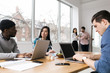 © ZeroThree - Young professionals working on laptops in an office