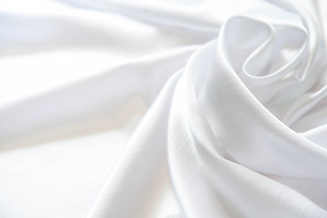 white shiny silk folded with soft folds. matte and glossy white fabric.