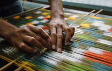 Weaving And Manufacturing Of Handmade Carpets Closeup. Man's Hands Behind A Loom