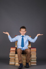 Wall Mural - Education funny idea. The smiling boy gesticulates hands as though weighing something