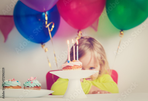 little girl making wish at birthday party Poster