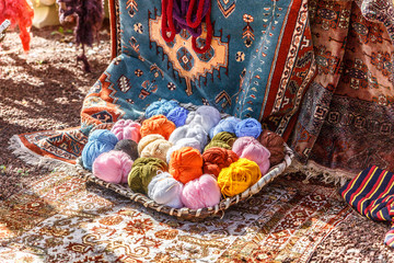 View of a set of wool balls next to  Persian carpets