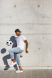 © Westend61 - Young man playing with soccer ball in front of concrete wall