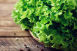Fresh organic lettuce salad on wooden background with pepper. Healthy food, raw and vegetarian concept with copy space.