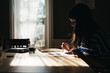 © LeaJones/Stocksy - young woman sitting at the table painting