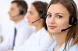 © rogerphoto - Call center operators. Focus at young beautiful business woman in headset