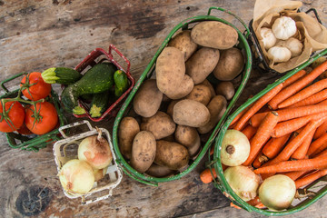 Wall Mural - Vegetables in metal baskets on distressed vintage wood background 