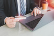 © bunditinay - Businessman shopping online with credit card and laptop in home office or co working space.Concept of e-commerce using mobile technology.