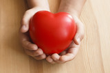 Fototapeta  - Heart in hand on wooden background