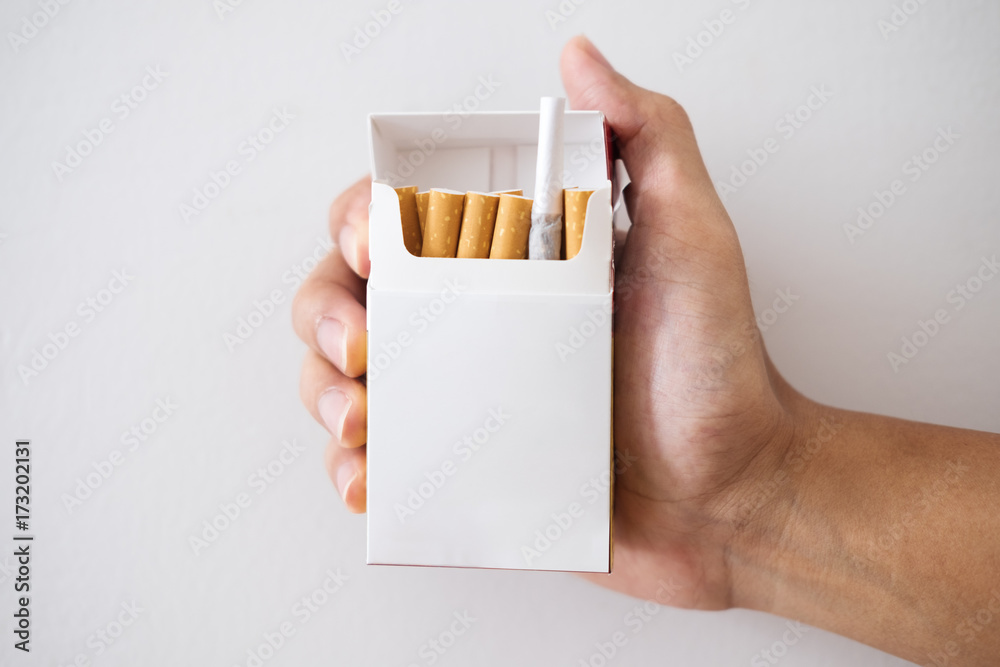 cigarette in hand luggage Hand holding cigarette box with hiding Marijuana rolled joint inside Stock  Photo