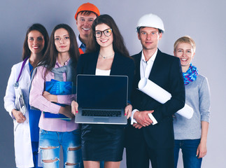 Smiling businesswoman with laptop  and group of industrial workers