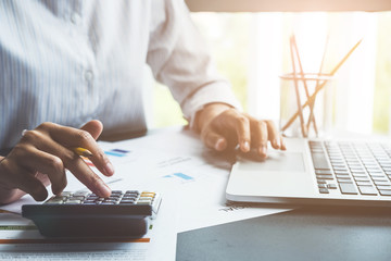 Close up view of Business analyzing investment charts with calculator laptop. Accounting and technology in office.Business people using laptop at office,Analyze plans.selective focus