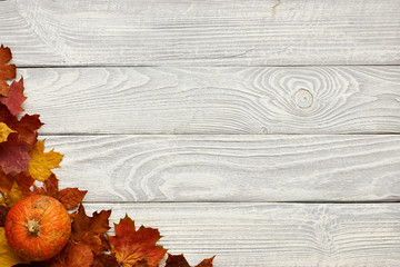 Poster - Autumn leaves and pumpkin over old wooden background