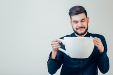 Business Man Holding A Funny Huge And Oversized Cup Of Black Coffee In Caffeine